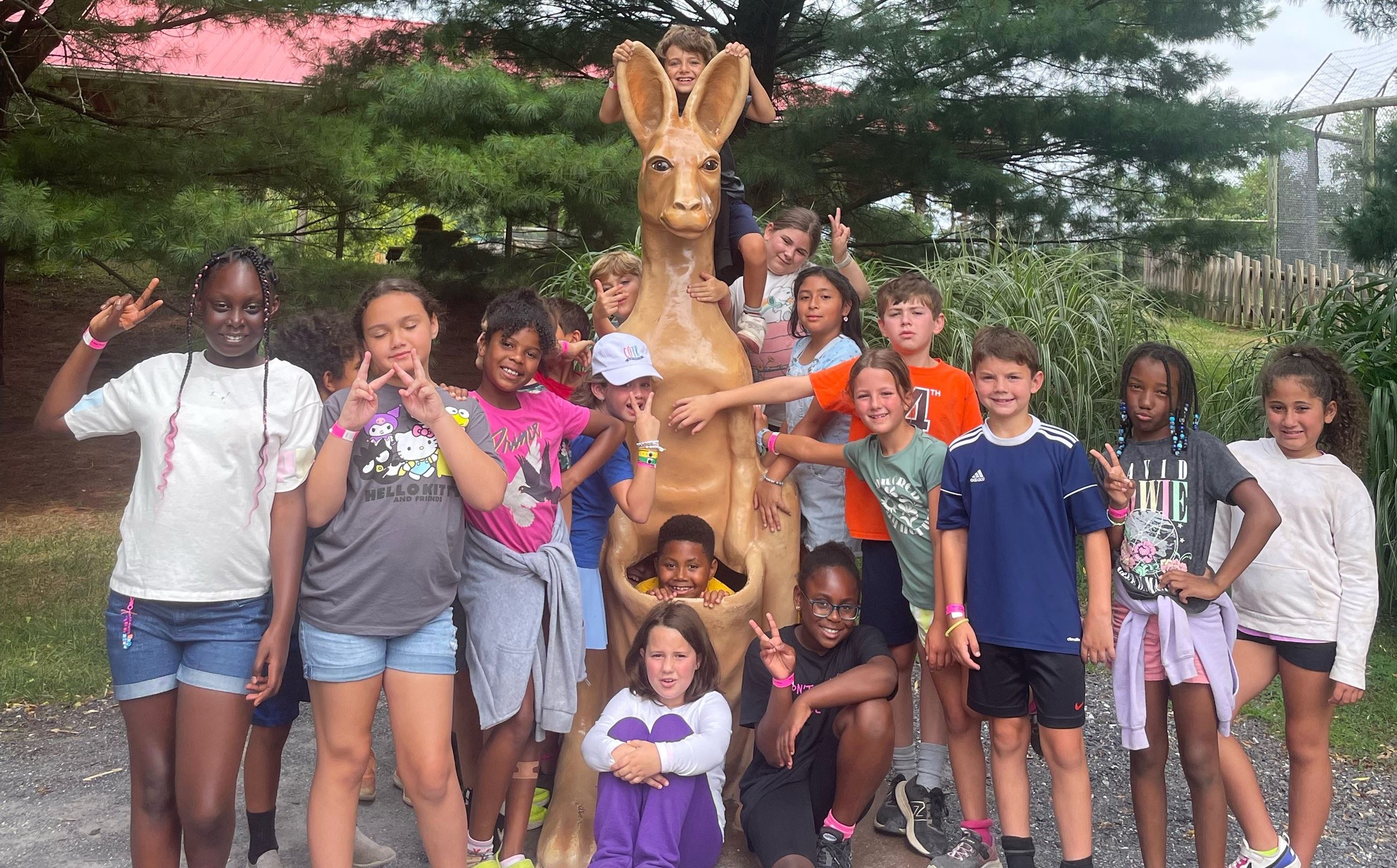 summer camp participants standing in front of knagaroo statue 