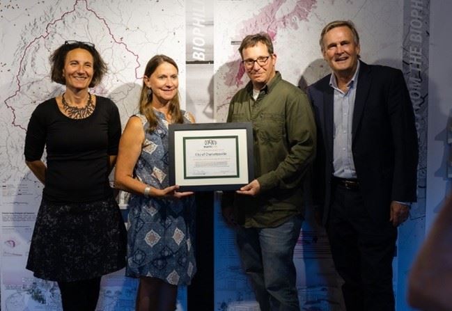 Sustainability Director Kristel Riddervold receives plaque from Biophilic Cities staff